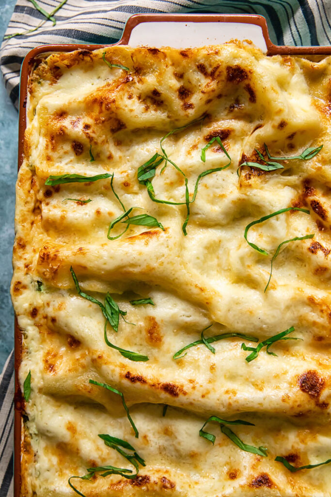 Pan of lasagne with pieces of basil on top