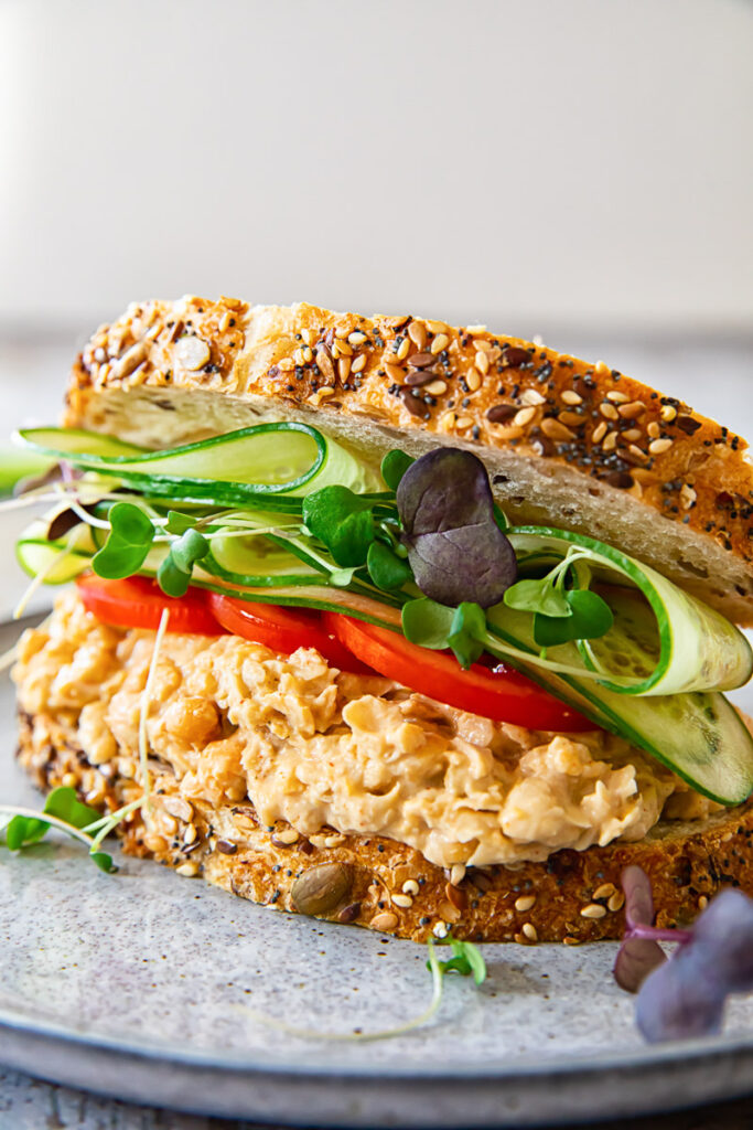 Angled view of chickpea salad sandwich on a plate