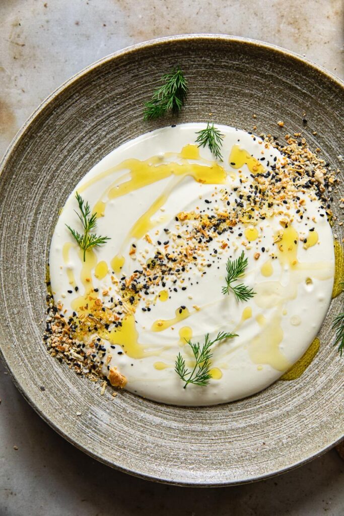 Whipped feta on a plate with topping and dill