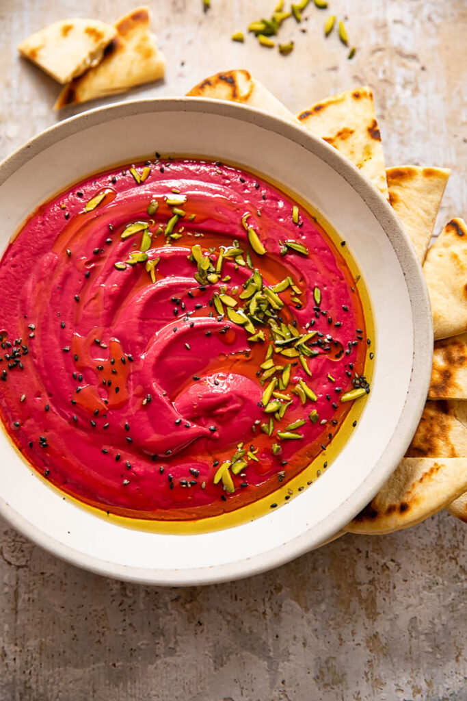 Top down of a bowl of beetroot borani with seeds on top